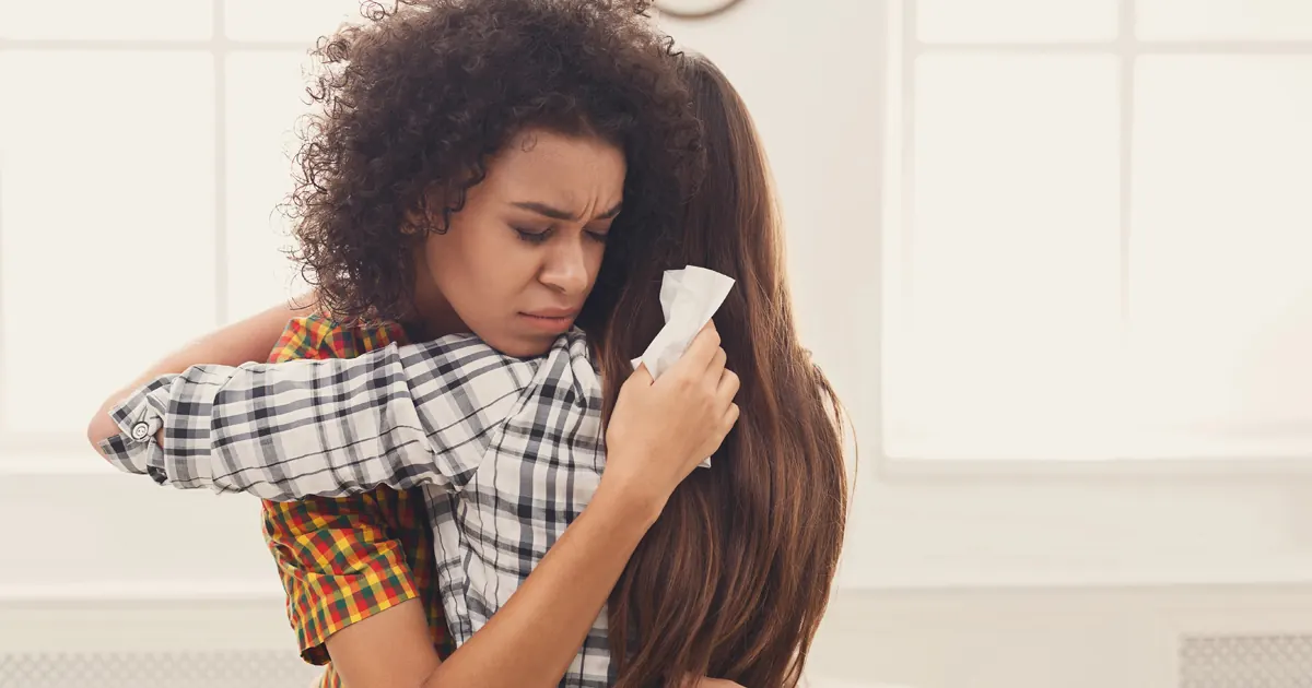Woman comforting a grieving friend with a hug