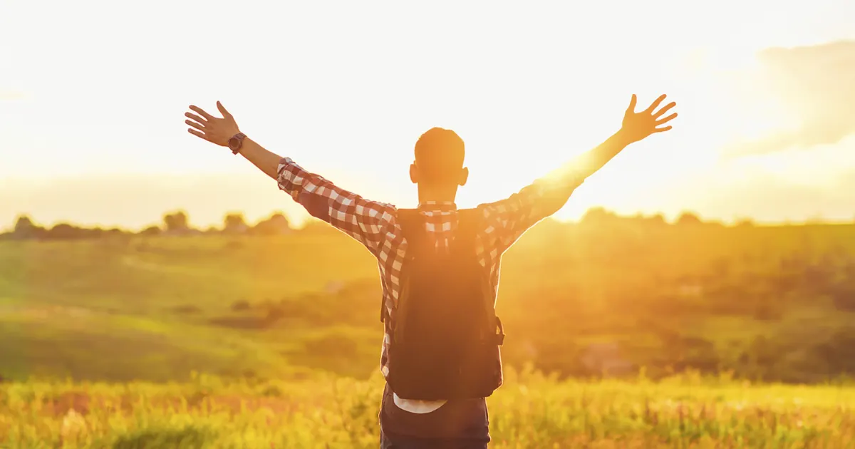 Discover the Benefits of Homeopathy for Skin Conditions Man with arms raised in a sunlit field