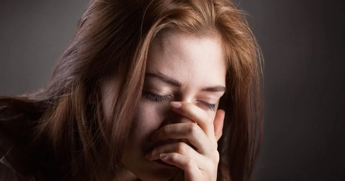 Woman with hand on face